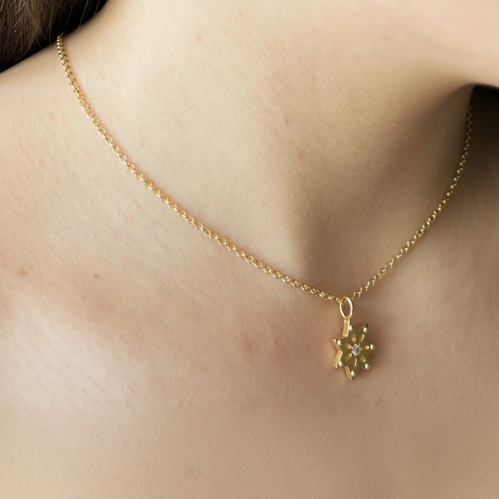 Gold necklace with a star pendant with zirkonia on a person's neck